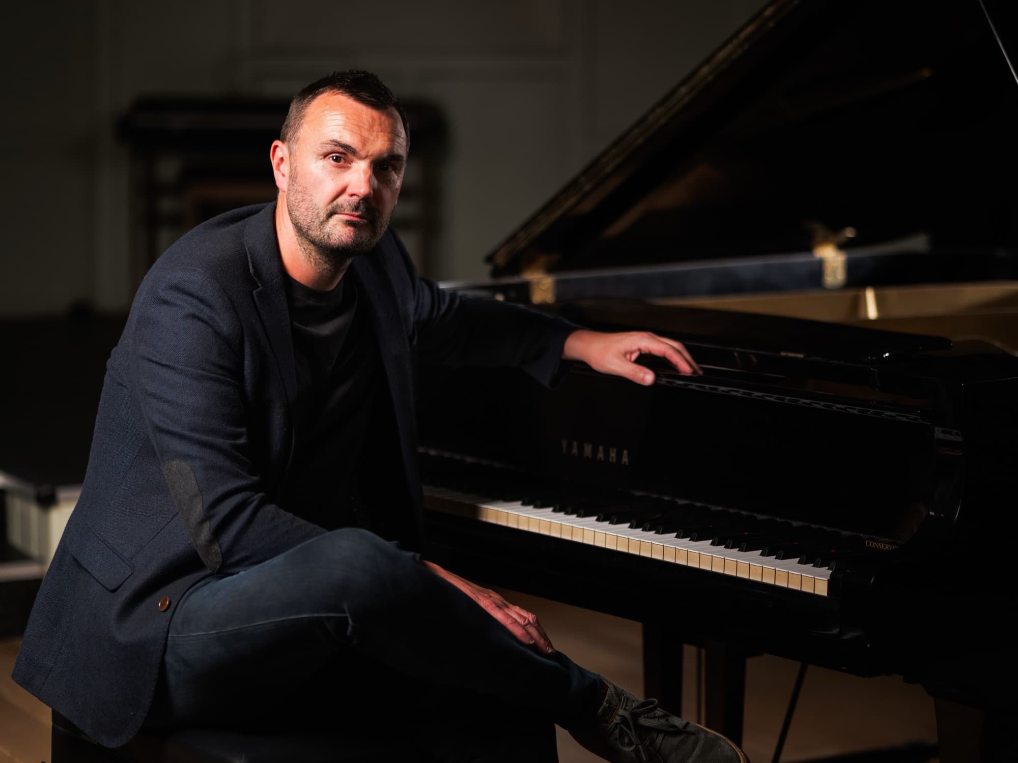 Phil Richardson seated at a grand piano