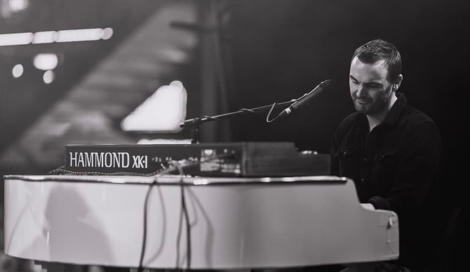 Phil Richardson playing keys live on stage with a band