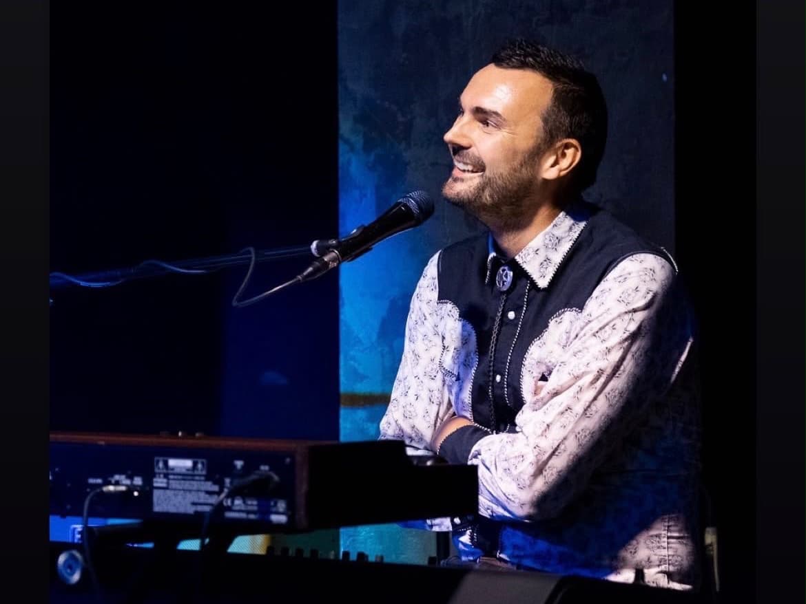 Phil Richardson singing and playing keys on stage