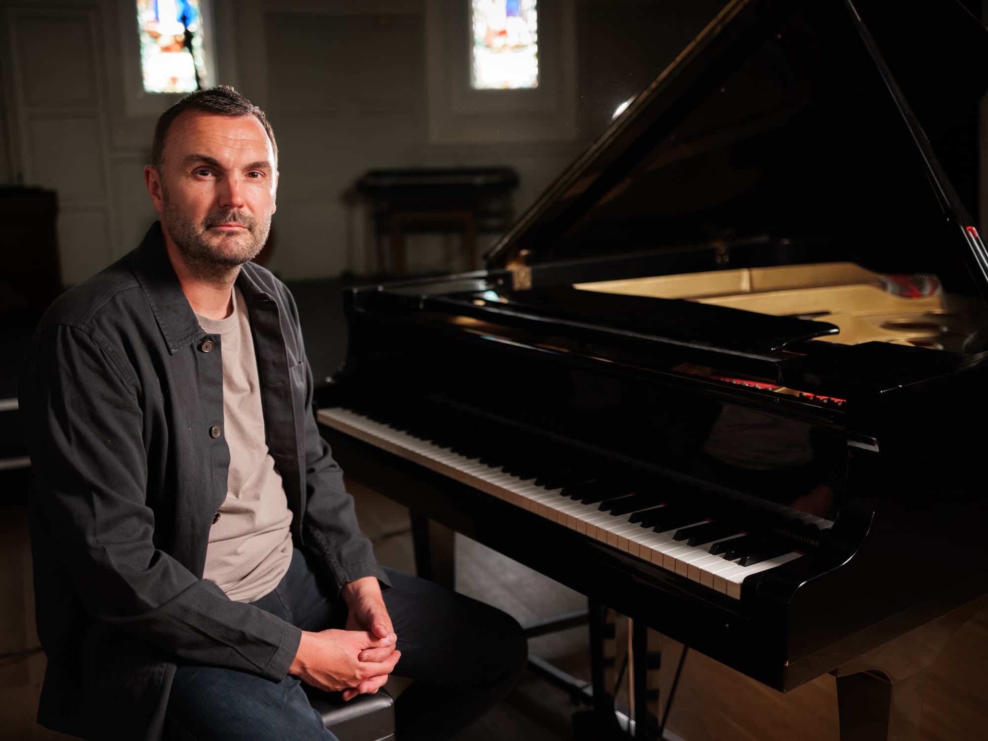 Phil Richardson seated in front of a grand piano
